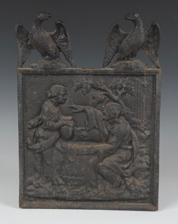SMALL IRON FIRE BACK WITH EAGLES: A depiction of Rebecca at the well in relief.
