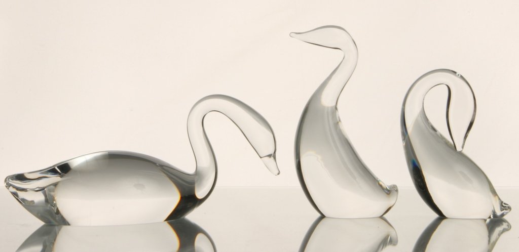 SET OF THREE STEUBEN ART GLASS CRYSTAL SWANS: Signed on their bases, measure 5.5, 4.25 and 3.5 x 8 inches.