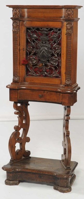 18TH CENTURY CONTINENTAL SACRISTY CABINET: A rectangular cabinet with concave central area and figural carved pilasters flanking the center door with cut openwork and embossed iron grill; scroll cut legs and conforming concave rectangular base
