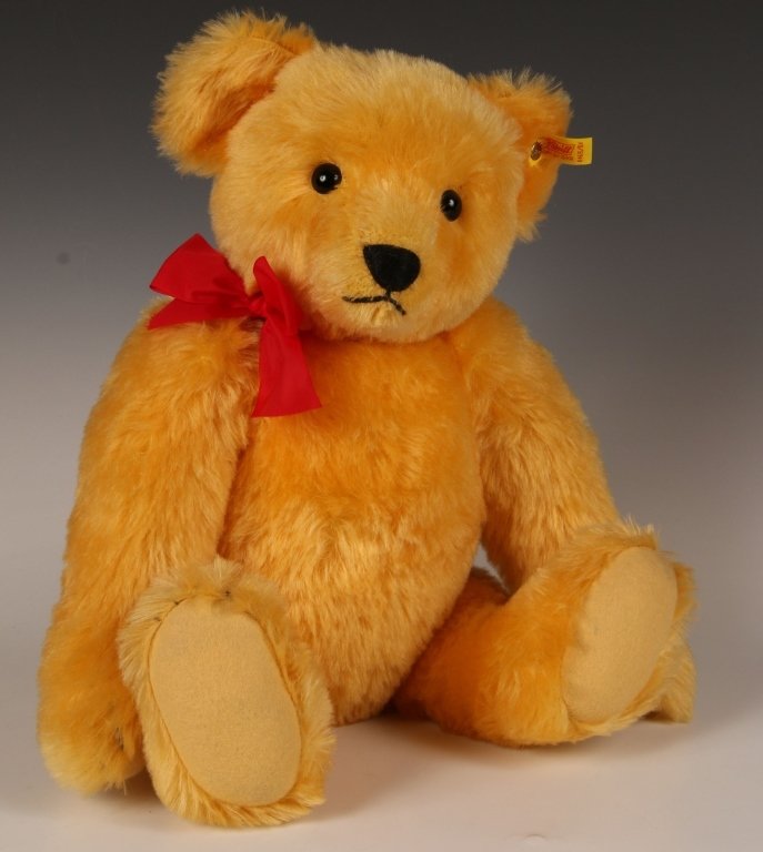 STEIFF 1909 REPLICA GOLD JOINTED BEAR 0165/21: Button eyes, humped back, horizontally stitched nose, gold mohair fur, felt paw pads, script button in ear, yellow tag, paper hang tags, measures 20 inches (50 cm) standing.