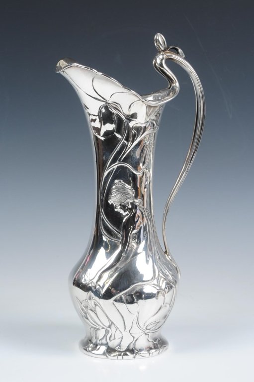 PAIRPOINT ART NOUVEAU SILVER PLATED EWER: With a high arching handle with organic form, embossed image of a nude maiden among flowing vines and blossoms, measures 14 x 6.5 inches. We ship in-house for all but very large and or very fragile it