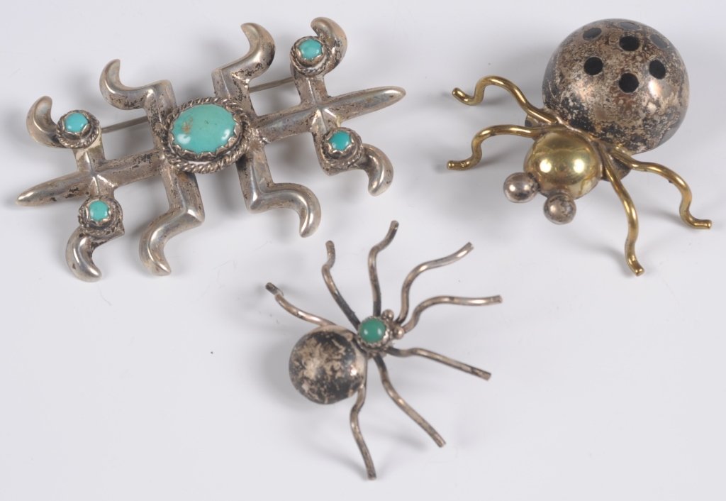 SILVER JEWELRY INCLUDING SAND CAST NAVAJO PIN WITH: A bug form pin stamped Taxco with inlaid onyx, a similar smaller pin with green stone, and a very nice Navajo brooch, unsigned. Group of three ranging in size from 1.5 inches in diameter, up to 3 x 1.