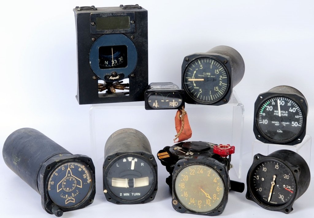 NINE DIFFERENT WWII-VIETNAM ERA INSTRUMENTS AND GAUGES: Lot consists of large master direction indicator, US Navy marked, has image of fighter plane on dial. Also two minute turn and bank indicator. Large eight day aircraft clock, appears to lack winding s