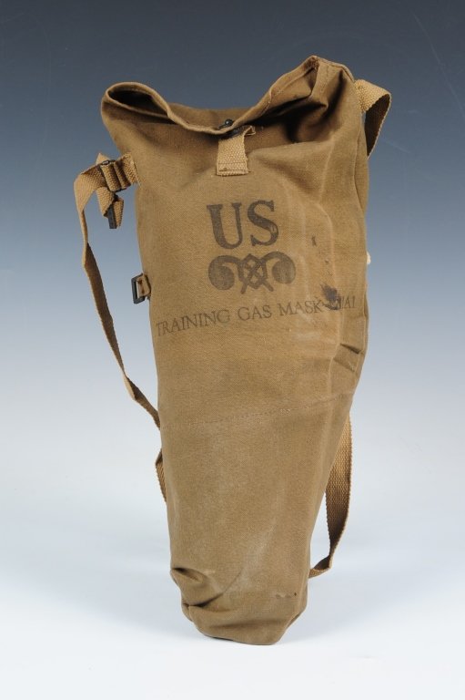 US WWII TRAINING GAS MASK AS USED BY PARATROOPERS: Tan canvas carrier in bag style with button down flap and adjustable shoulder sling, boldly marked with US chemical insignia on front. And reads Training Gas Mask M1A1. Contains mask assembly that app