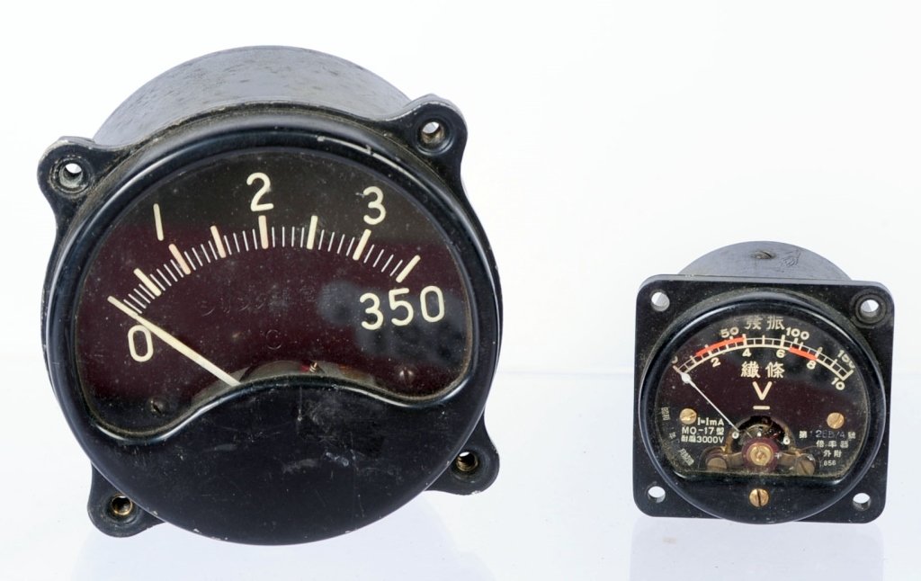 TWO WWII JAPANESE AIRCRAFT INSTRUMENTS: Small instrument appears to be volt gauge for mounting in instrument panel, two threaded terminals on reverse. The second instrument is a large size black face with Japanese military data plate on rev