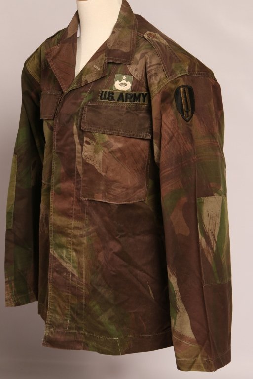 VIETNAM AMERICAN ADVISORS CAMOFLAUGE UNIFORM: Two piece uniform in South Vietnamese camouflage pattern similar to French army lizard pattern. Features button front shirt with large cargo pockets, US Army republic Vietnam sleeve patch on left shou