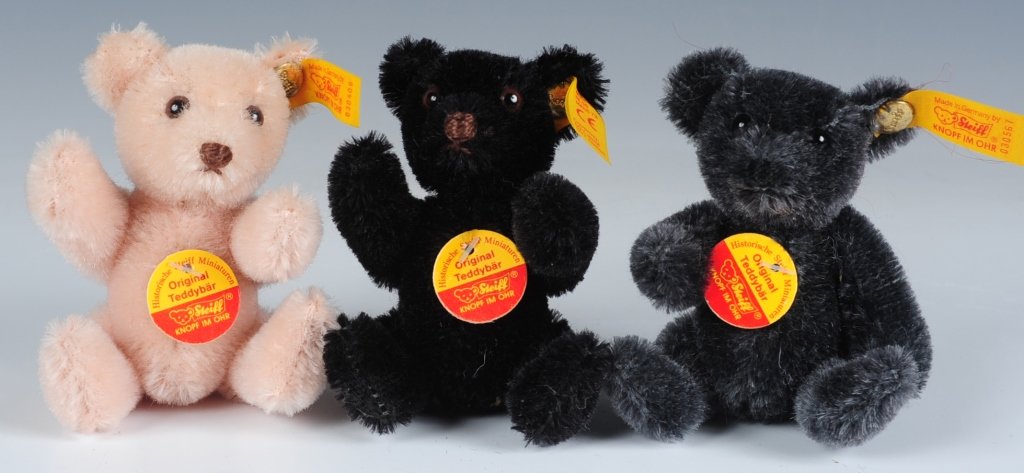 THREE MINIATURE STEIFF TEDDY BEARS: Miniature bears in black, charcoal and rose, numbers 030505, 030567 and 030406, buttons in ears with yellow tags, chest hang tags, measure 3.25 inches sitting.