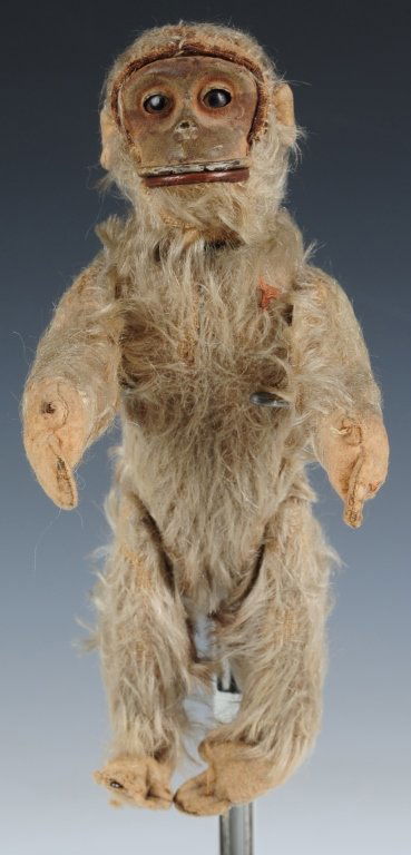 SHUCO YES-NO MONKEY: Schuco yes-no monkey, mohair body, composite face, felt paws, mechanism in the tail moves his head, measures 9 inches standing, signs of age and use with some mohair loss and holes in the felt pads on