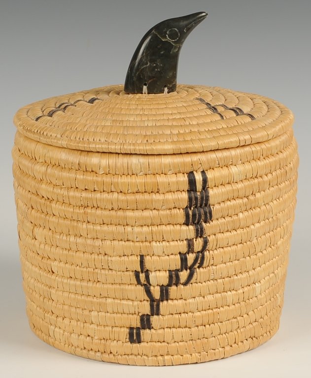 ELISAPEE WEETALUKTUK INUIT BASKET WITH SOAPSTONE: A lime grass basket with soap stone bird head finial, attributed to Elisapee Weetaluktuk. Measures 10.5 x 9.25 inches diameter. ?We are happy to offer in-house shipping for all but very large or very 