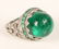AN ART DECO CABOCHON EMERALD AND DIAMOND PLATINUM RING