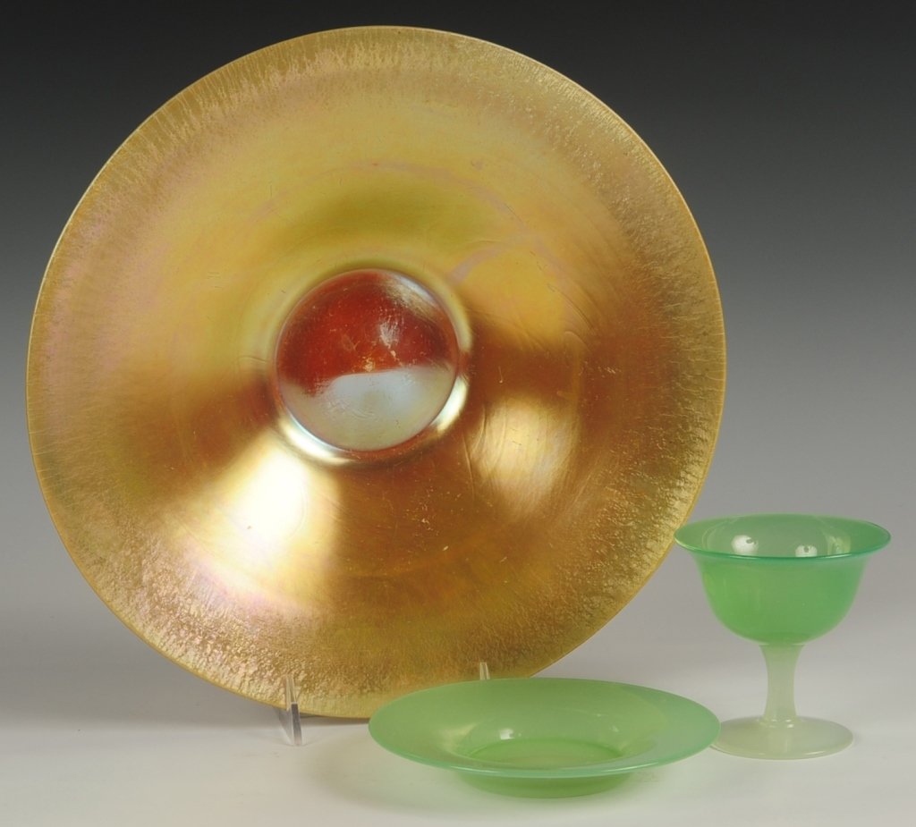 THREE PIECES STEUBEN ART GLASS: A Steuben Aurene gold charger with Calcite base, unmarked, measures 13 inches. Plus a green jade Steuben sherbet with underplate, unmarked, sherbet measures 4 x 4 inches, underplate 6.25 inches. ?We a