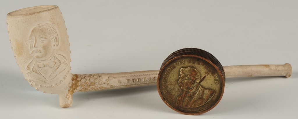 GROVER CLEVELAND POLITICAL SOUVENIRS: A plaster pipe with embossed patriotic and campaign slogans as well as patriotic emblems measures 6.25 inches. Plus an 1892 coin container with busts of Cleveland and Stevenson with motto MY STACK ON