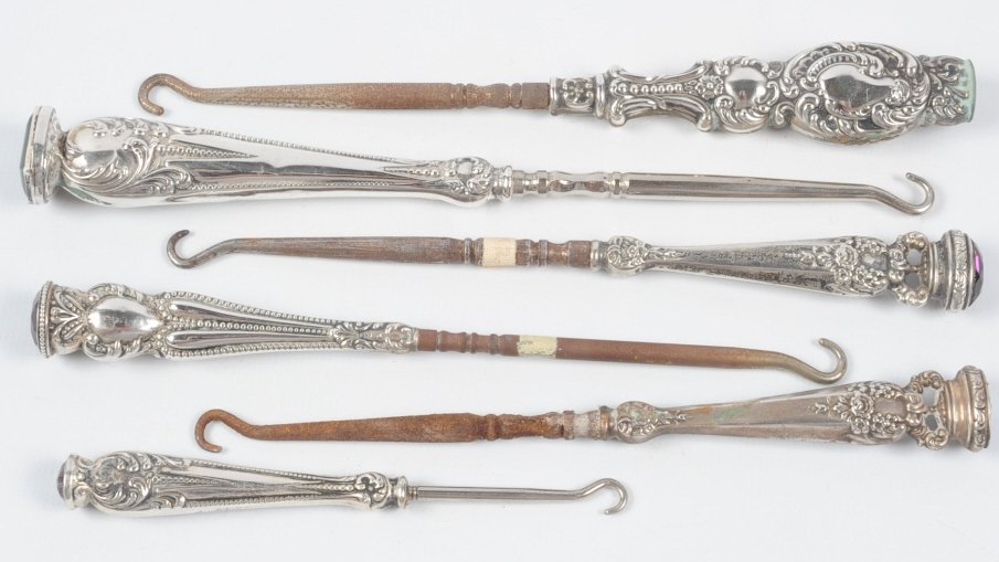 ANTIQUE STERLING BUTTON HOOKS WITH JEWELS: Six button hooks with jeweled finials, all are marked sterling, three have maker's marks for Foster & Bailey, one for Marcus Merriman Co., measure 4.25 to 7.5 inches. This lot is not from the Mundwyle