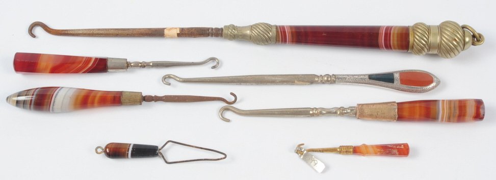 LOT OF AGATE HANDLE VICTORIAN BUTTON HOOKS: Seven antique button hooks, one 1911 button hook has carnelian and onyx inlaid in Birmingham sterling and is hallmarked, lot measures from 2.5 to 11 inches. This lot is not from the Mundwyler-Moulthro