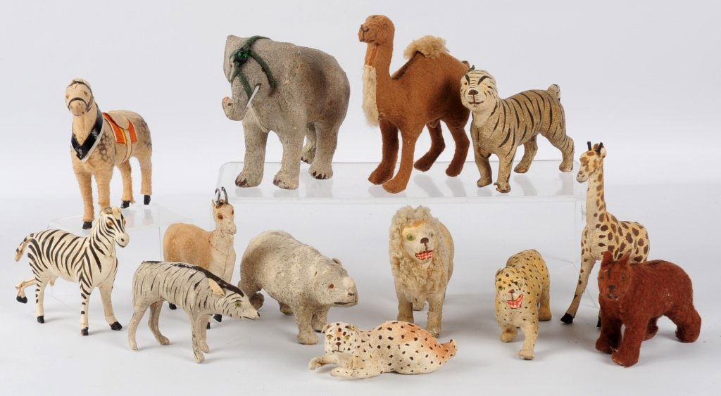 TWELVE 19TH CENTURY HIDE-COVERED ANIMAL TOYS: Includes: hide-covered elephant, tiger, lion, roe buck, and hyena; felt covered bear, camel and circus pony. Five other hide-covered toy animals with broken legs. We are happy to offer in-house shippi