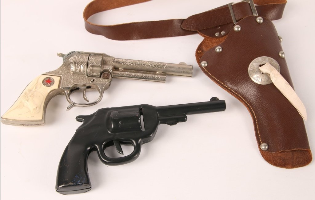 TEXAN JR. CAP GUN AND HOLSTER BELT, PLUS A TOY GUN: Texan Jr. cap gun with a leather holster, gun measures 8.5 inches. Plus a black metal toy pistol with a mechanical clicker, measures 7.5 inches. We are happy to offer in-house shipping for all but ver