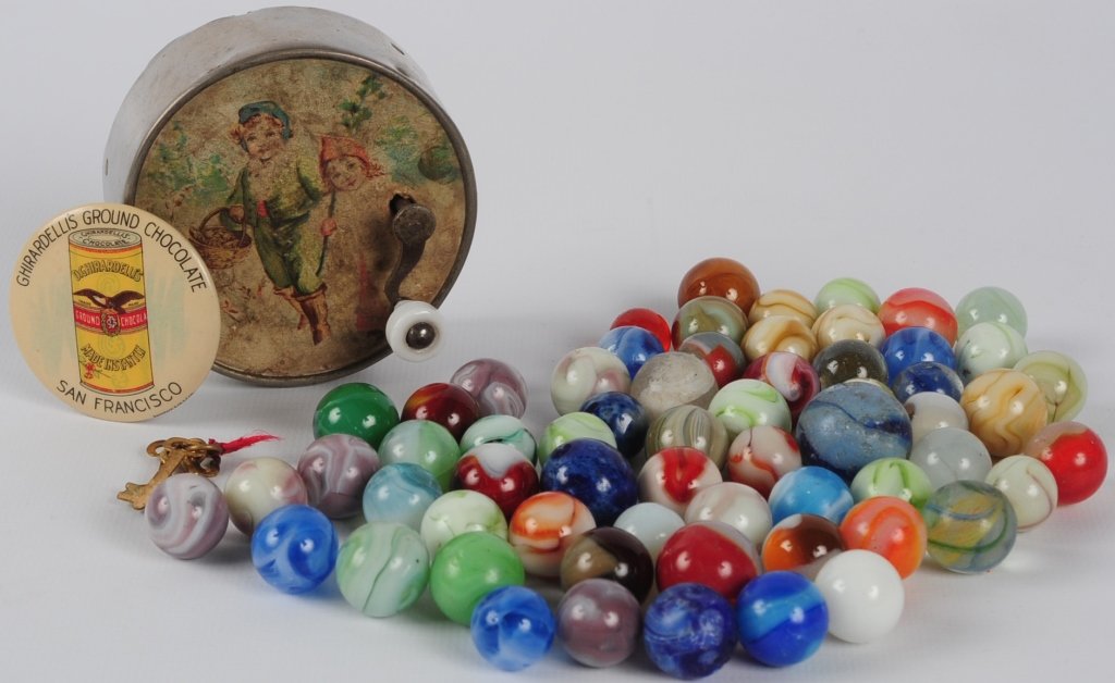 ESTATE LOT OF MARBLES AND NOVELTIES: Advertising pocket mirror for Ghirardelli's Ground Chocolate measures 1.75 inches, hand crank music box plays 'The Mosquitos Parade', marbles include latticino swirl and two Bennington machine made fr