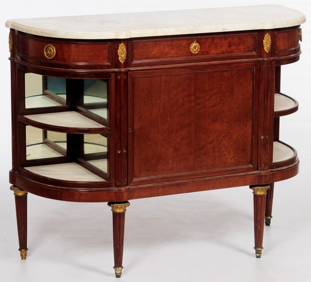 A Jansen LOUIS XVI BRONZE MOUNTED Commode l'Anglaise: Having a D-shaped white marble top over a central frieze drawer flanked by two side drawers above a cupboard door enclosing a plain interior with one shelf, the quarter-lune ends fitted with encoignur