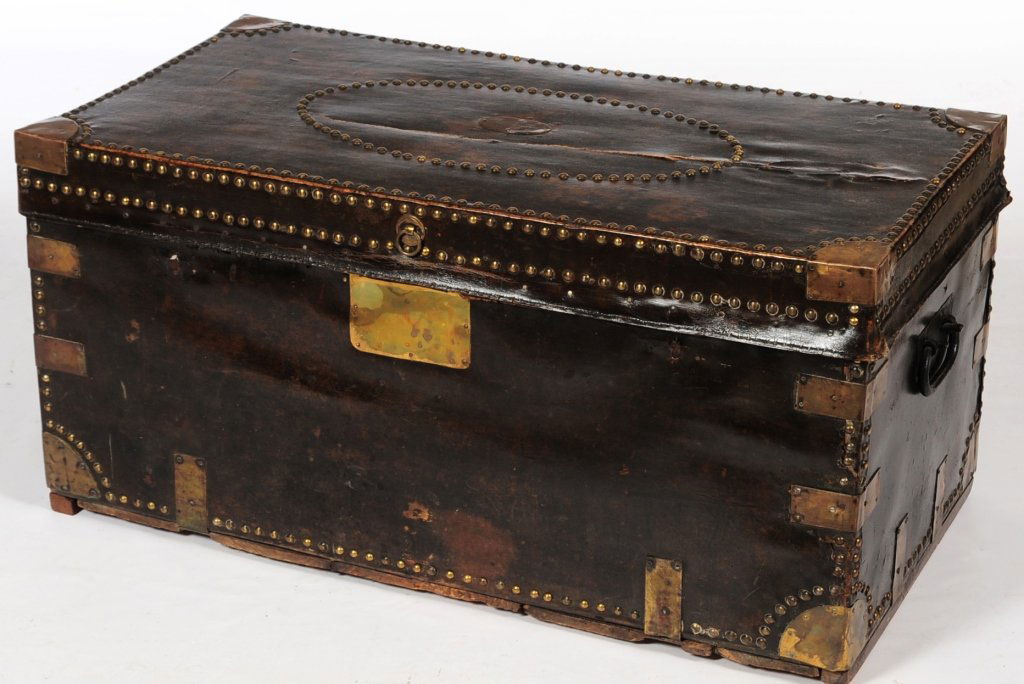 A VICTORIAN LEATHER AND BRASS BOUND TRUNK: Rectangular form with hinged flat lid, flanked by handles and embellished overall with nail heads and brass corners and fittings. Label in the lid from Danielle and Son, Portman Square. Measures 21 x