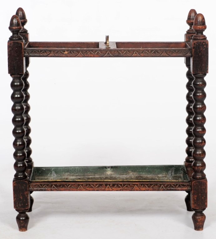 A JACOBEAN STYLE STAINED OAK UMBRELLA AND CANE STAND: Measures 28 x 24 x 10 inches.We are happy to offer in-house shipping for all but very large or very fragile items. Some international orders may need to be handled by a third party shipper. Handling a