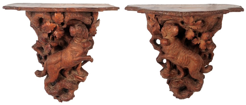 19TH C. SWISS BLACK FOREST FIGURAL DOG CARVED SHELVES: A proper pair of carved walnut shelves centered by a canine figure on rustic base surrounded by carved oak leaves. Great quality of carving and nice warm patina. measure 16.5 x 20 x 11.5 inches each.W
