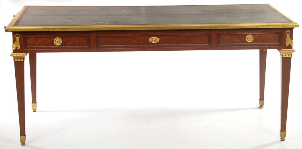 A LOUIS XVI BRONZE MOUNTED BUREAU PLAT: Gilt bronze-bound rectangular tooled leather surface, over frieze with three paneled drawers fitted with laurel loop handles and escutcheon, writing slides over paneled sides, gilt swag mounts and mol