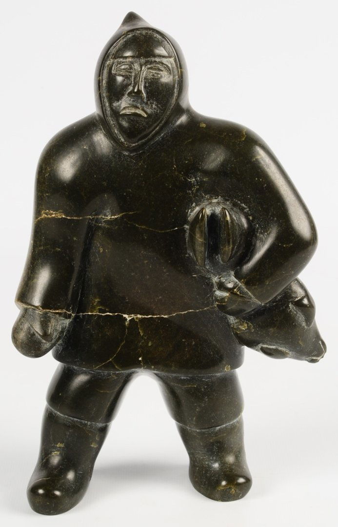 AN INUIT SOAPSTONE SCULPTURE OF MAN CARRYING A SEAL (1 of 10)
