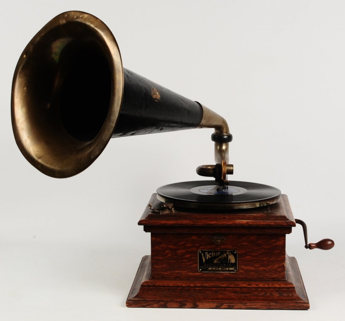 VICTOR II ANTIQUE OAK CASE PHONOGRAPH: With original brass bell horn and Victor decal on the horn and metal tag on the case. Measures 21.5 x 14 x 22 inches.We are happy to offer in-house shipping for all but very large or very fragile item