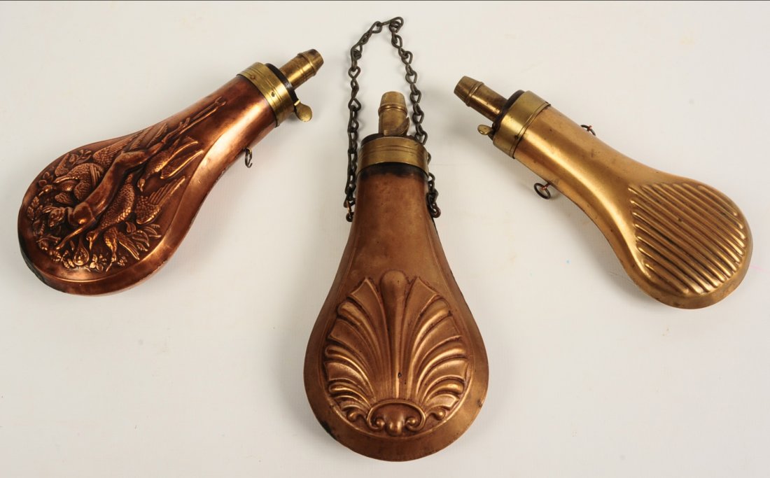 THREE 19TH C. EMBOSSED COPPER GUNPOWDER FLASKS: Three pieces ranging in size from 6.75 x 2.75 inches up to 7.5 x 3.5 inches.We are happy to offer in-house shipping for all but very large or very fragile items. Some international orders may need to