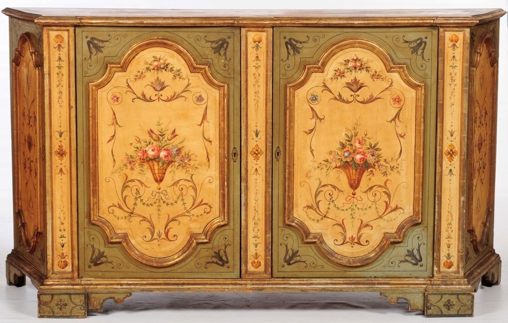19TH CENTURY ITALIAN POLYCHROME VENETIAN CREDENZA: Shaped trapezoidal top with projecting corners centering a large shaped reserve featuring a painted floral bouquet surrounded by shells and foliate, above a conforming case fitted with a central pair