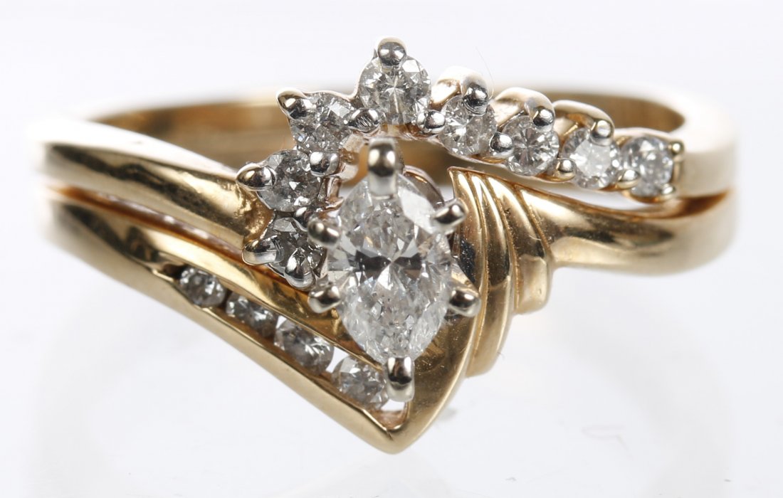 14K MARQUISE DIAMOND ENGAGEMENT WEDDING BAND: An approximate .20ct. Marquise diamond with four channel set diamond on the engagement ring and eight full cut diamonds set in wedding band. Both rings are soldered together and measure a size 6.5, we