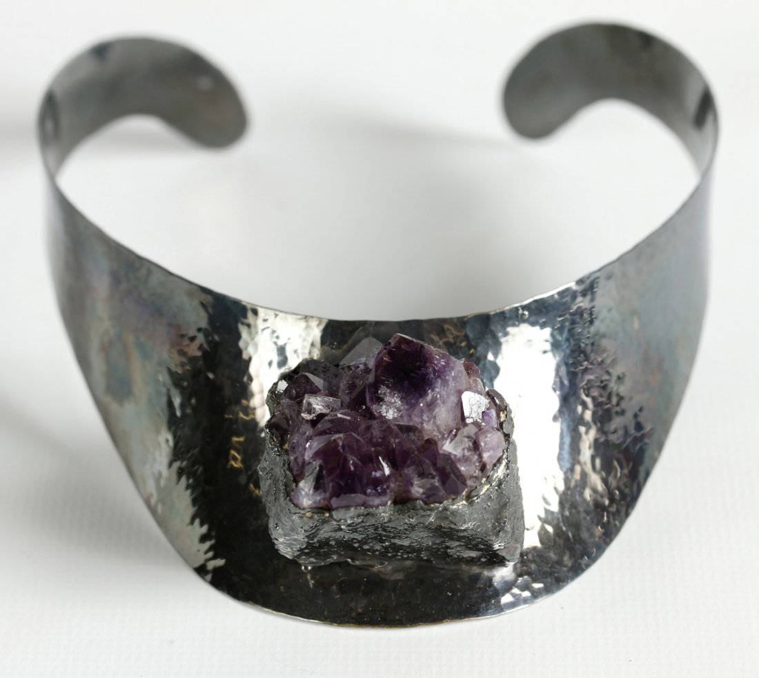 JACOB HULL STERLING SILVER COLLAR WITH AMETHYST: A sterling collar necklace with an uncut amethyst crystal drop, artist's mark on the back, amethyst measures 30 x 35 mm, collar width 1.5 inches, necklace size approximately 12.5 inches. We happily pr