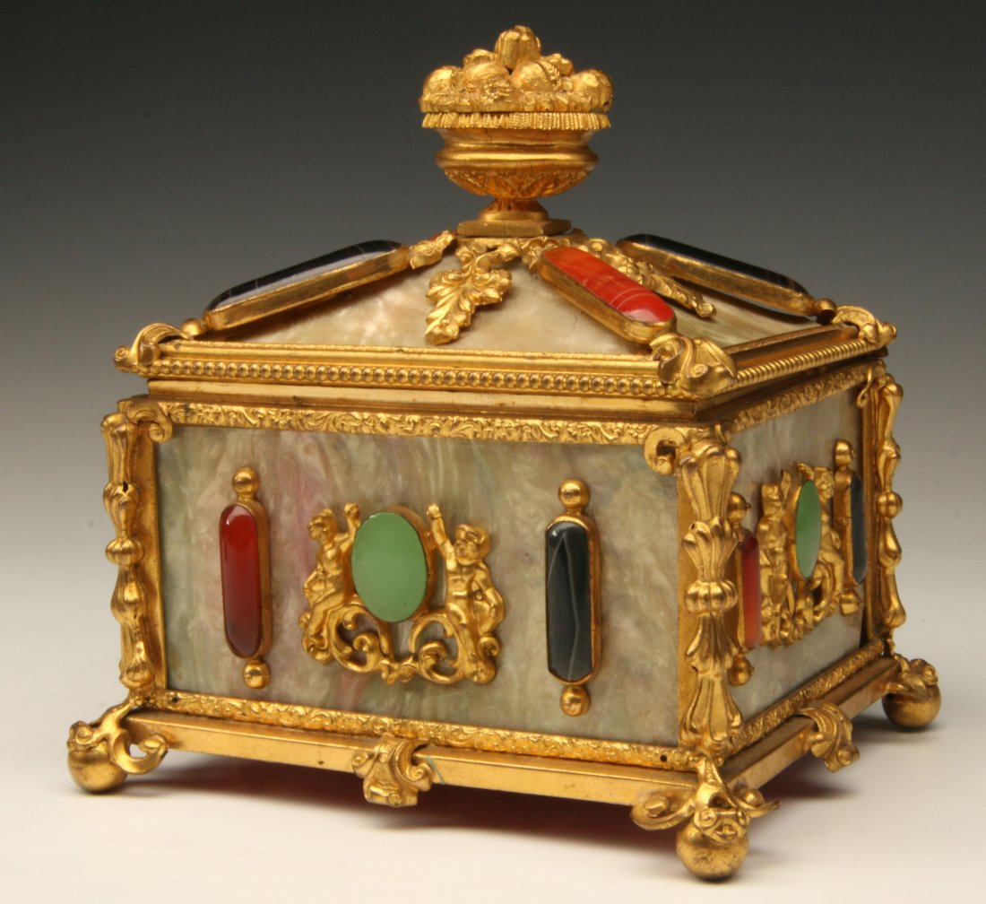 19TH C. FRENCH ORMOLU, SHELL & SEMI-PRECIOUS STONE BOX: An ornate gilded metal framework with thin panels of Mother-of-Pearl and bezel set goldstone, jadeite, carnelian and other agates, gilded metal ornaments and a hand stippled ormolu bronze fruit basket