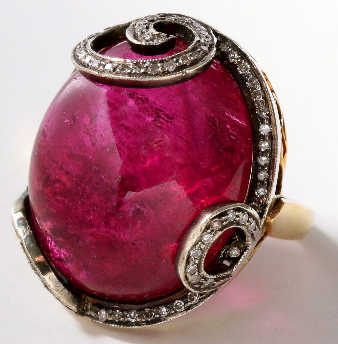 AN 18K TOURMALINE CABOCHON FASHION RING WITH DIAMONDS: An 18k gold setting marked inside the band, the Tourmaline cabochon measures 23 x 20 mm, ring size 7.5, weighs 16.8 grams.