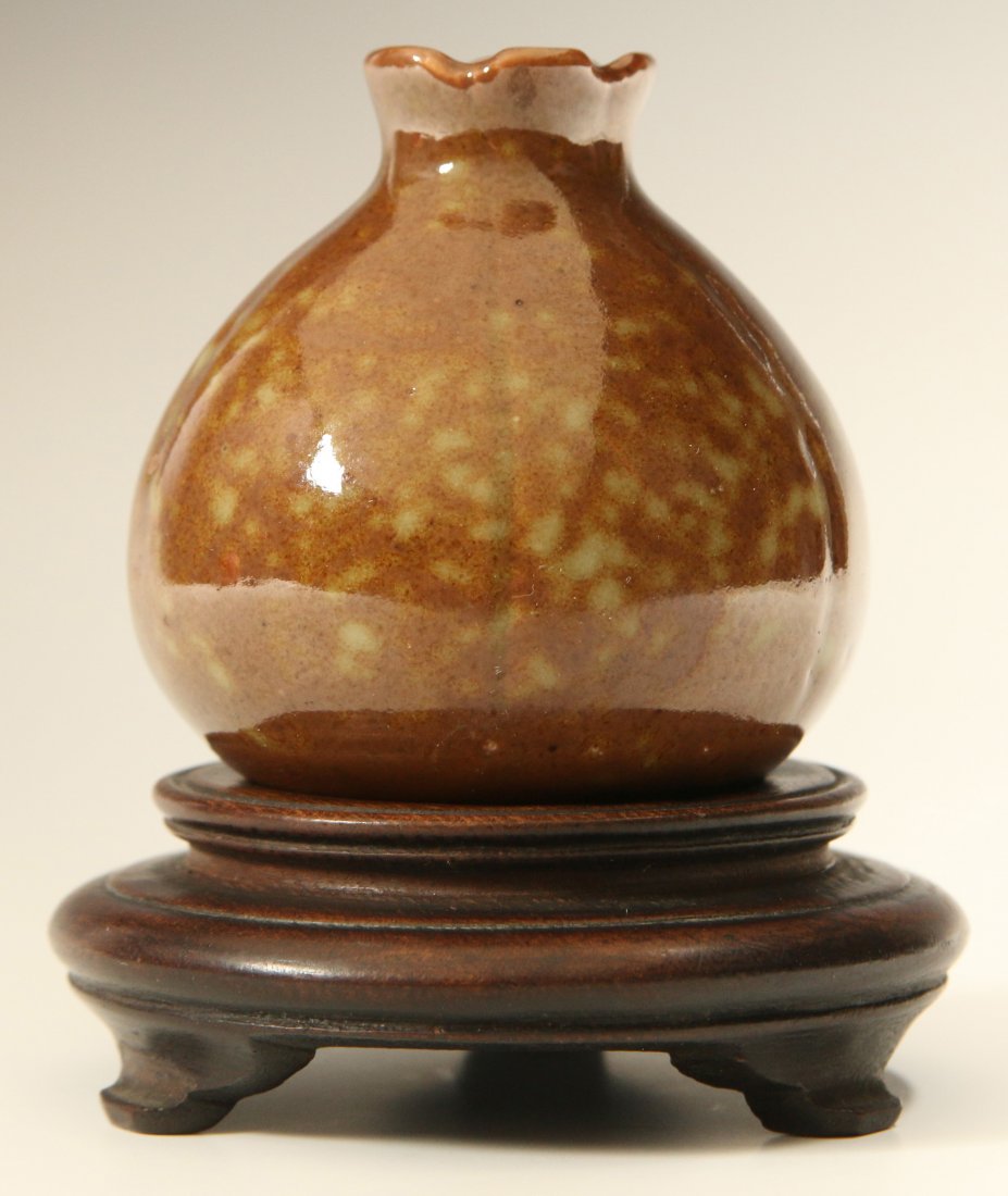 AN ANTIQUE CHINESE MOTTLED BROWN PORCELAIN BOTTLE: Chinese mottled brown glazed porcelain bottle with fluted lip; apocryphal Kangxi reign base mark. Measures 3.5 x 3.25 inches including stand.