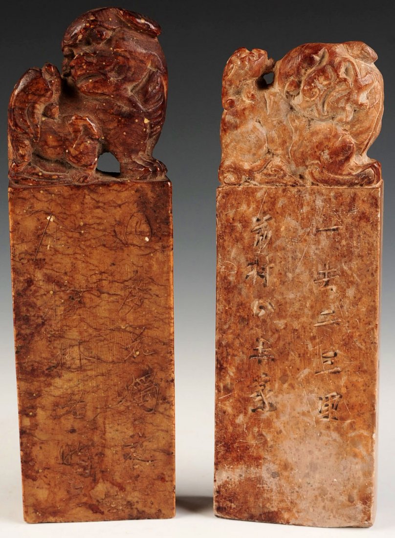 A PAIR CHINESE CARVED SOAPSTONE FU DOGS: Chinese, pair of tall soapstone seals with sculpted carvings of Fu Dogs. Inscriptions to sides. Pair measures 7 x 2.25 inches.