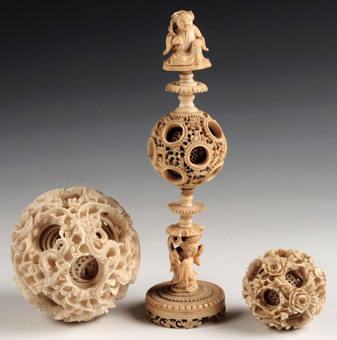 THREE CHINESE CARVED IVORY MYSTERY BALLS: The largest with dragons in relief, the taller with figural man and woman, the sizes range from 2 inches in diameter up to 3.75 inches diameter and 8h x 2.25 inches.