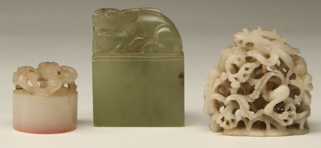 THREE SMALL ANTIQUE CHINESE CARVED JADE OBJECTS: A group of three small Chinese carved jade objects; the first a round seal of white jade with serpentine animal; the second, an unused rectangular form seal of pale green jade with reclining Fu Dog; t