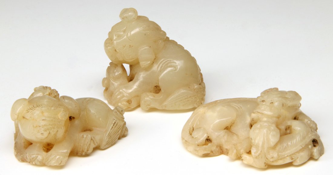 THREE CHINESE CARVED WHITE JADE FU DOGS: Chinese, three small white jade Fu Dogs. Sizes 1 x 1.75 inch up to 1 x 2.25 inches.