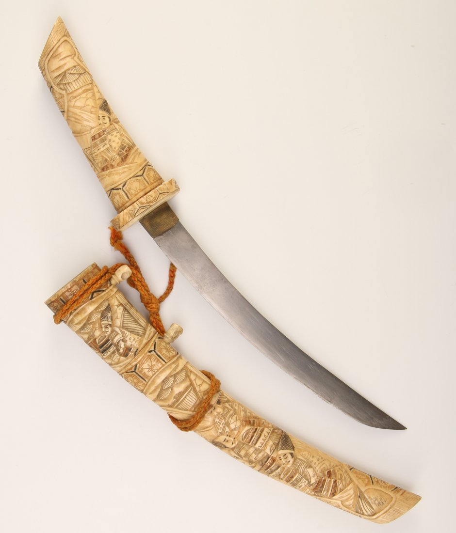 AN ANTIQUE JAPANESE WAKIZASHI WITH SAMURAI: A Japanese short sword (wakizashi) with carved bone sheath having designs of samurai figures, late 19th-early 20th century. Measures 1 x 13.25 inches.