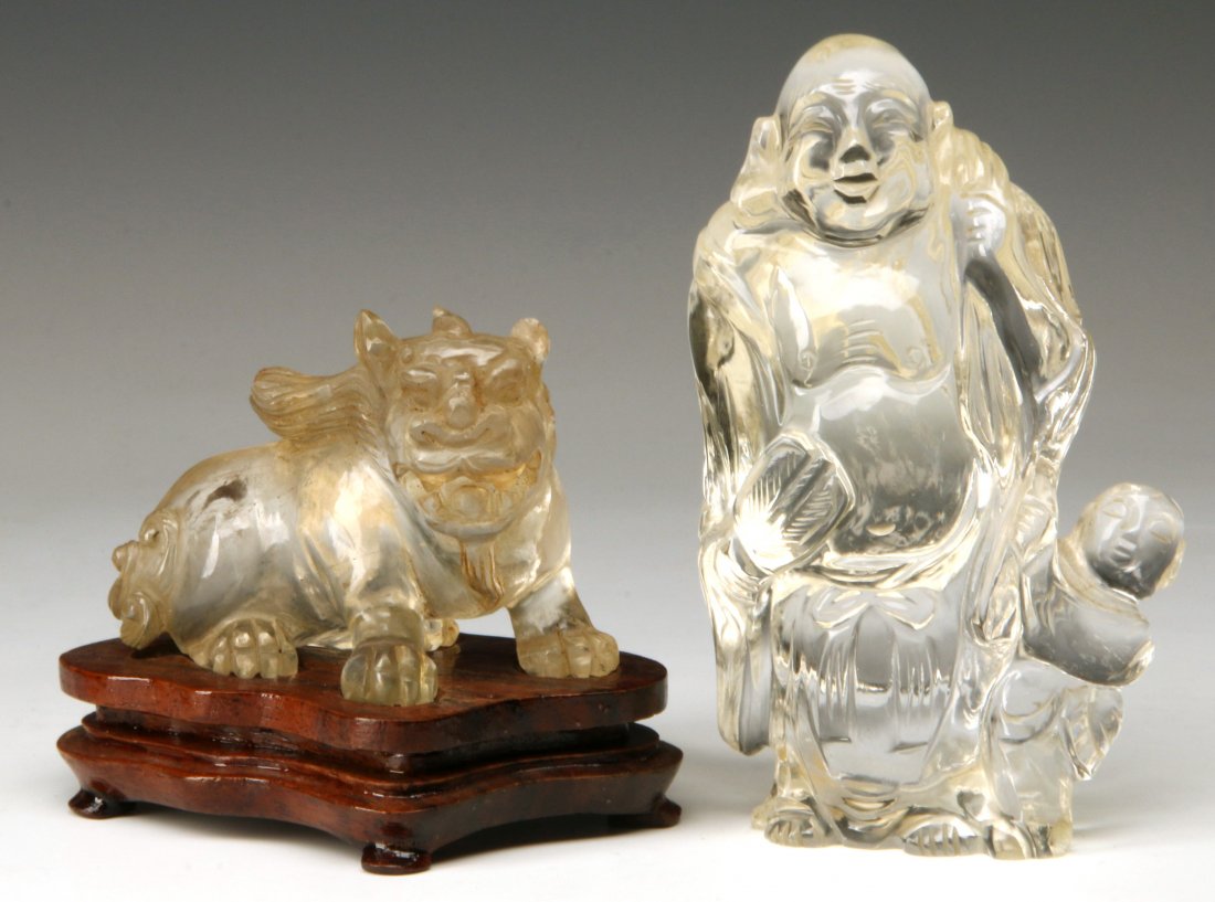 TWO CHINESE CARVED ROCK CRYSTAL FIGURES: Two Chinese carvings; one representing a Qilin mythical animal and the other the figure of Putai with a small child. Measures with stand 2.75 x 3.75 and 4.25 x 4.75 inches.