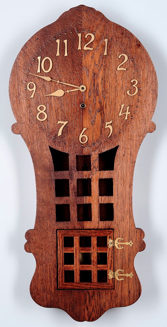 A SESSIONS 'RAMONA' MISSION OAK STYLE WALL CLOCK: A good Mission style oak clock circa 1910, applied brass numerals and hinges, eight day time and strike movement. Measures 31.5 x 15 x 4.25 inches.