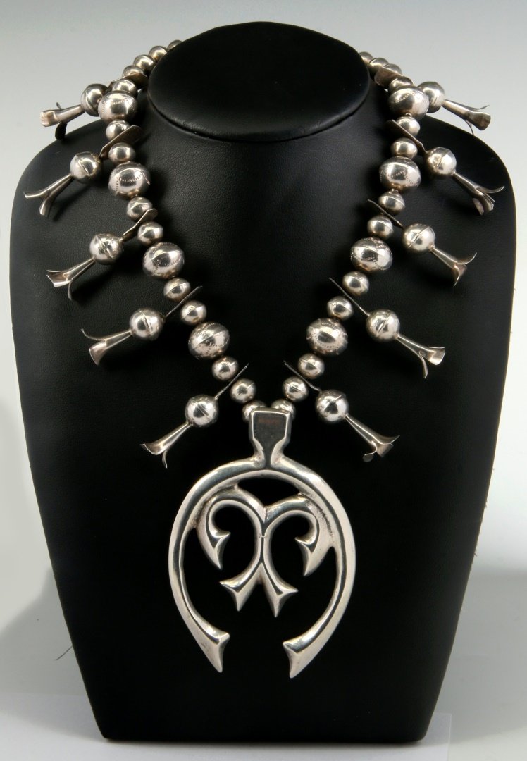 A STERLING SQUASH BLOSSOM NECKLACE WITH SAND CAST NAJA: Unsigned, pendant measures 3.5 x 2.25, necklace length 28 inches.