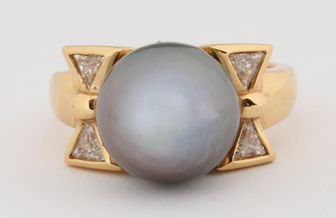 A LADIES 18K GOLD TAHITIAN PEARL AND DIAMOND RING: The 11mm Tahitian pearl is flanked by two trillion cut diamonds on each side to create a 'bow' appearance, diamonds have a 0.35ct total weight. Ring measures a size 6 and weighs 9 grams.