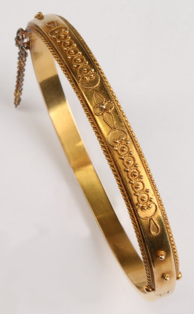 A 15C GOLD BANGLE BRACELET: Marked 15c on the clasp, the hidden clasp also supports a safety chain, weighs 12 grams.