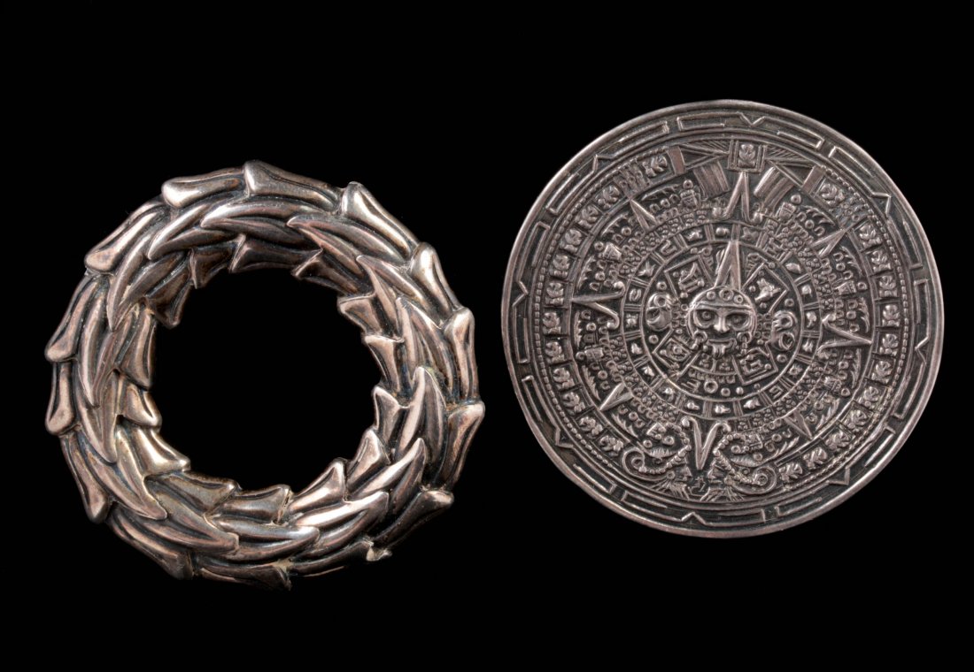 TWO TAXCO STERLING SILVER BROOCHES: Two large brooches with a wreath and a Mayan calendar, marked on the backs, measure 2.25 inches each.