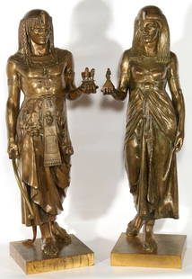 EMILE PICAULT (1833-1915) EGYPTIAN REVIVAL BRONZE PAIR: Male and female figures in Egyptian attire, the male sculpture referred to as 'The Pharaoh's Gift', the female figure 'The Queen's Offering', each signed E. PICAULT on the base, original golden patina