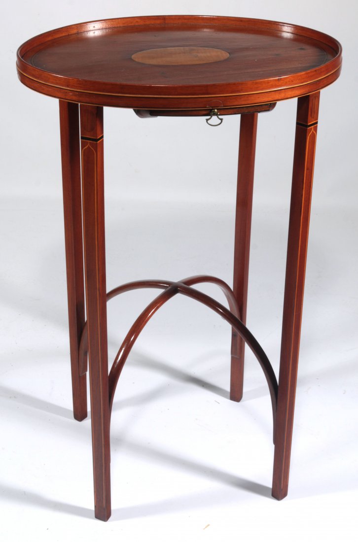 A PERIOD AMERICAN HEPPLEWHITE KETTLE STAND OF RARE FORM: A Period American Hepplewhite kettle stand with unusual semi-elliptical arching stretchers. The oval mahogany top with full gallery is banded in light colored veneers bordered by birch-colored line in