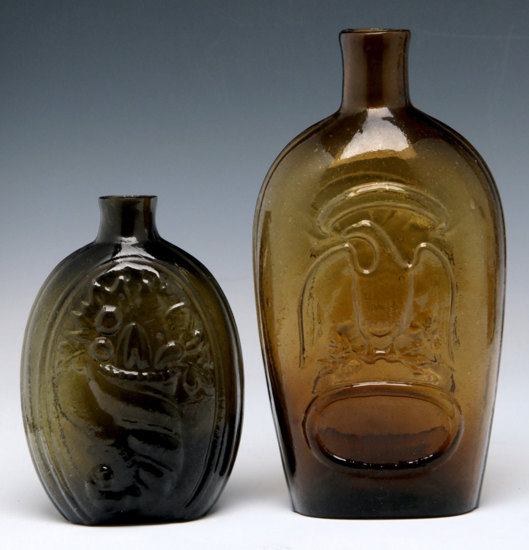 TWO 19TH C. AMERICAN HISTORICAL FLASKS: McKearin GIII - 7 Cornucopia page 551 of American Glass: By George S. and Helen McKearin in dark green measures 5.5 x 3.5 inches. Plus a light amber eagle flask 7.75 x 4 inches. We ship in-house for a