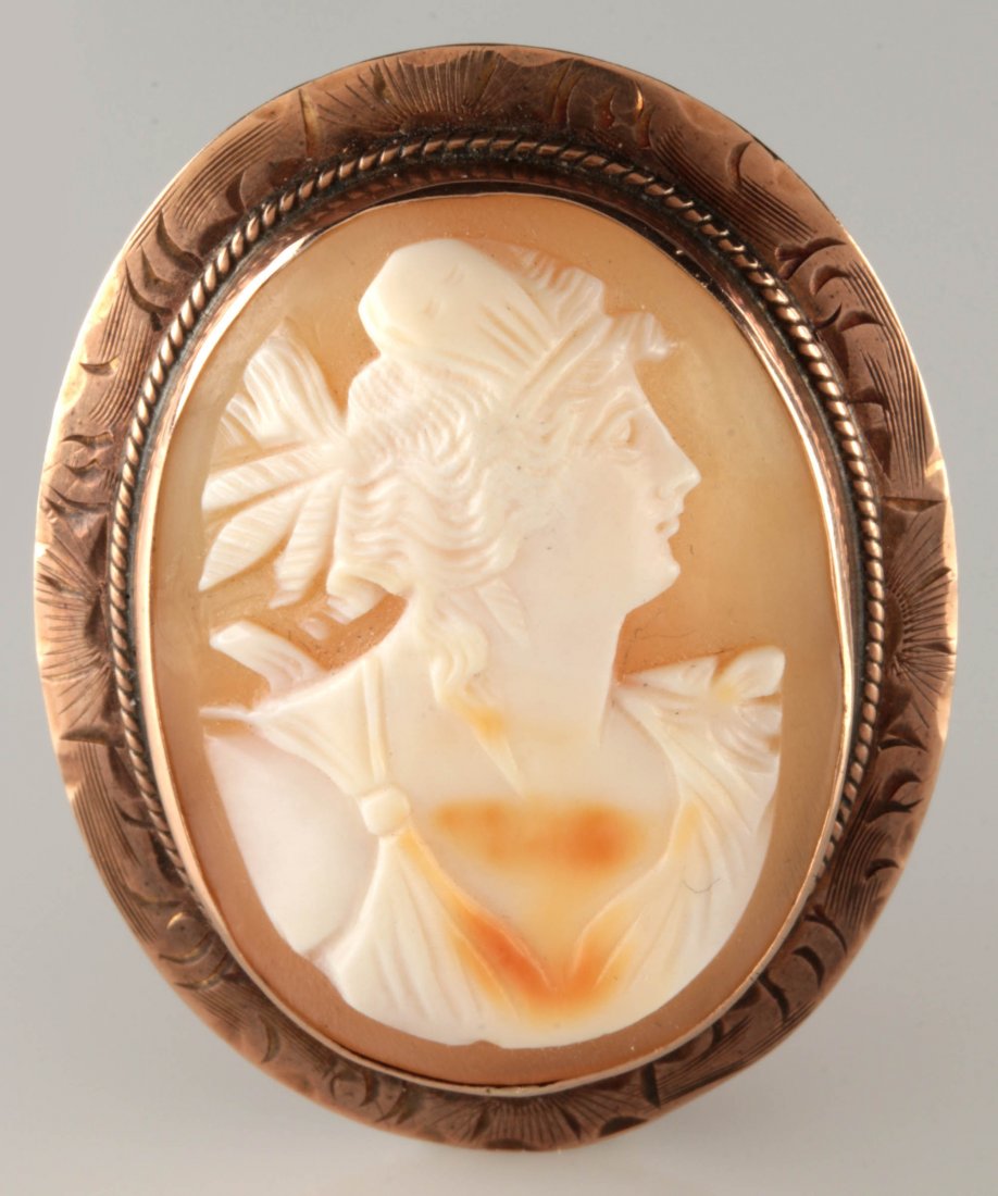 AN ANTIQUE CARVED SHELL CAMEO IN 10K GOLD: An antique carved shell cameo in a 10k gold bezel, with a pin back and a hinged necklace bail, unmarked, tests for 10k gold, measures 1.5 x 1.25 inches, weighs 7.5 grams. We ship in-house for all item